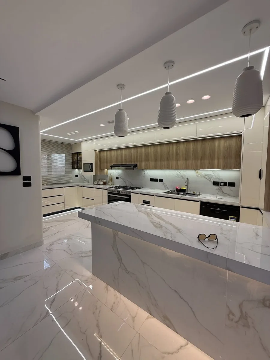 Inspirasi dapur mewah luas warna putih gading (ivory) dengan lantai marmer motif besar dan pencahayaan LED strip modern.