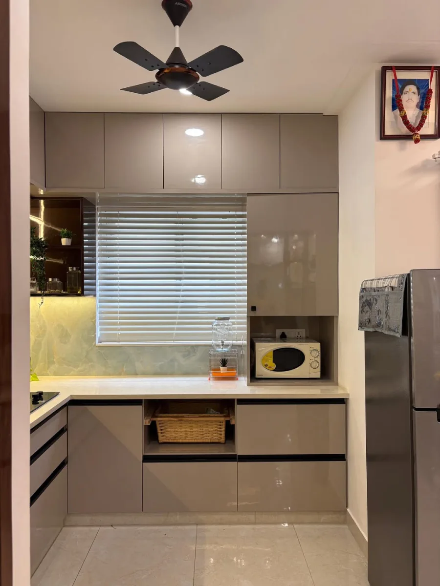 Desain dapur mungil fungsional warna greige (abu-kecokelatan) dengan jendela berpenutup venetian blinds untuk sirkulasi udara.