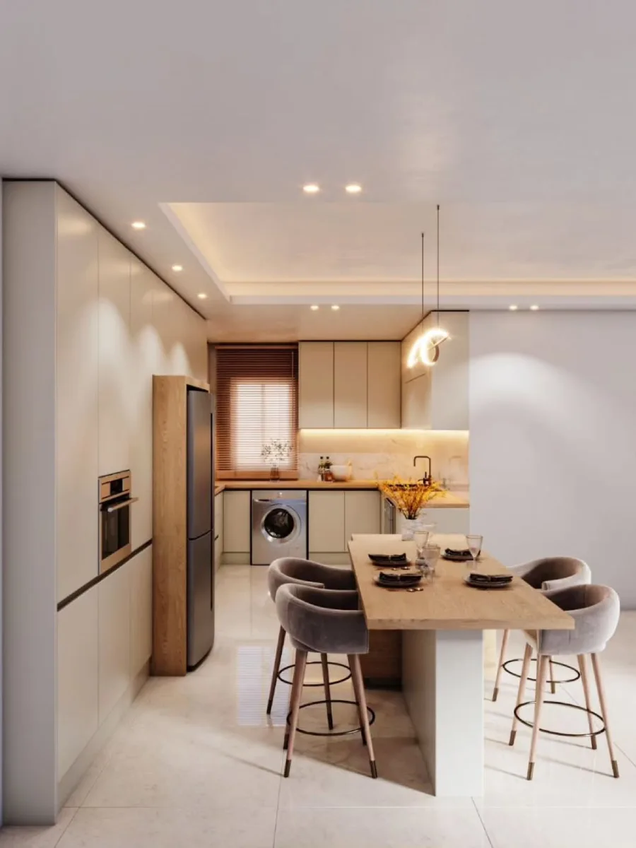 Detail interior dapur konsep open plan dengan meja makan kayu light wood dan kursi bar velvet abu-abu yang nyaman.