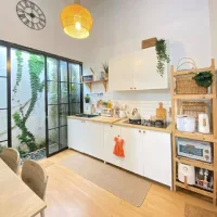 Inspirasi dapur minimalis modern yang menyatu dengan ruang makan (open plan), dilengkapi pintu kaca geser menghadap taman samping untuk pencahayaan alami maksimal.