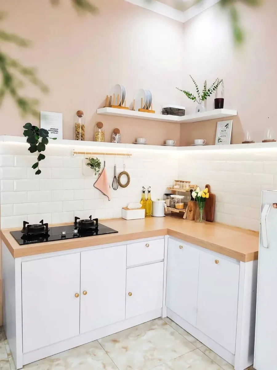 Dapur minimalis bergaya Scandinavian bentuk L dengan meja kayu solid (butcher block), keramik dinding subway tile putih, dan rak sudut ambalan dengan lampu LED strip.