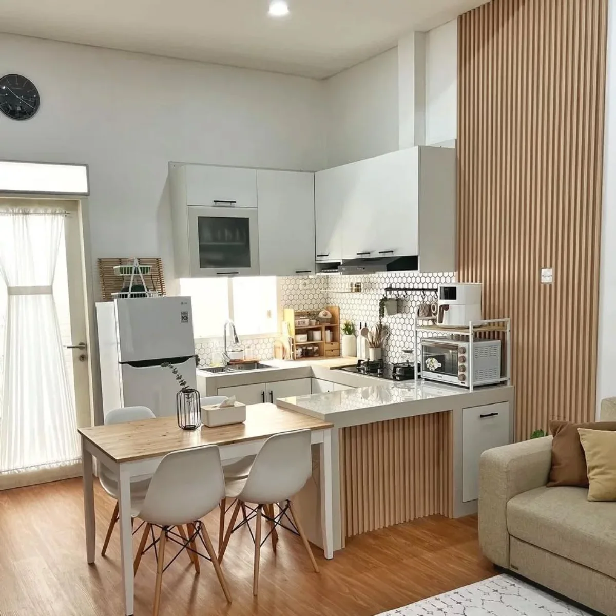 Interior dapur minimalis estetik dengan aksen dinding panel kayu (wood slat), backsplash keramik heksagonal, dan meja bar mini berbentuk L yang hemat tempat.