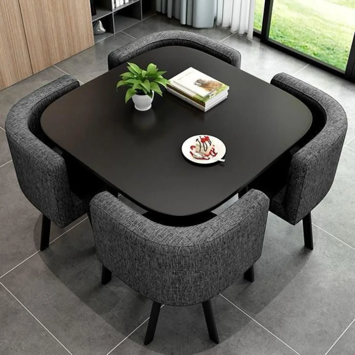 Set meja makan minimalis berbentuk persegi berwarna hitam dengan empat kursi abu-abu bertekstur yang didesain pas masuk ke bawah meja untuk menghemat ruang.