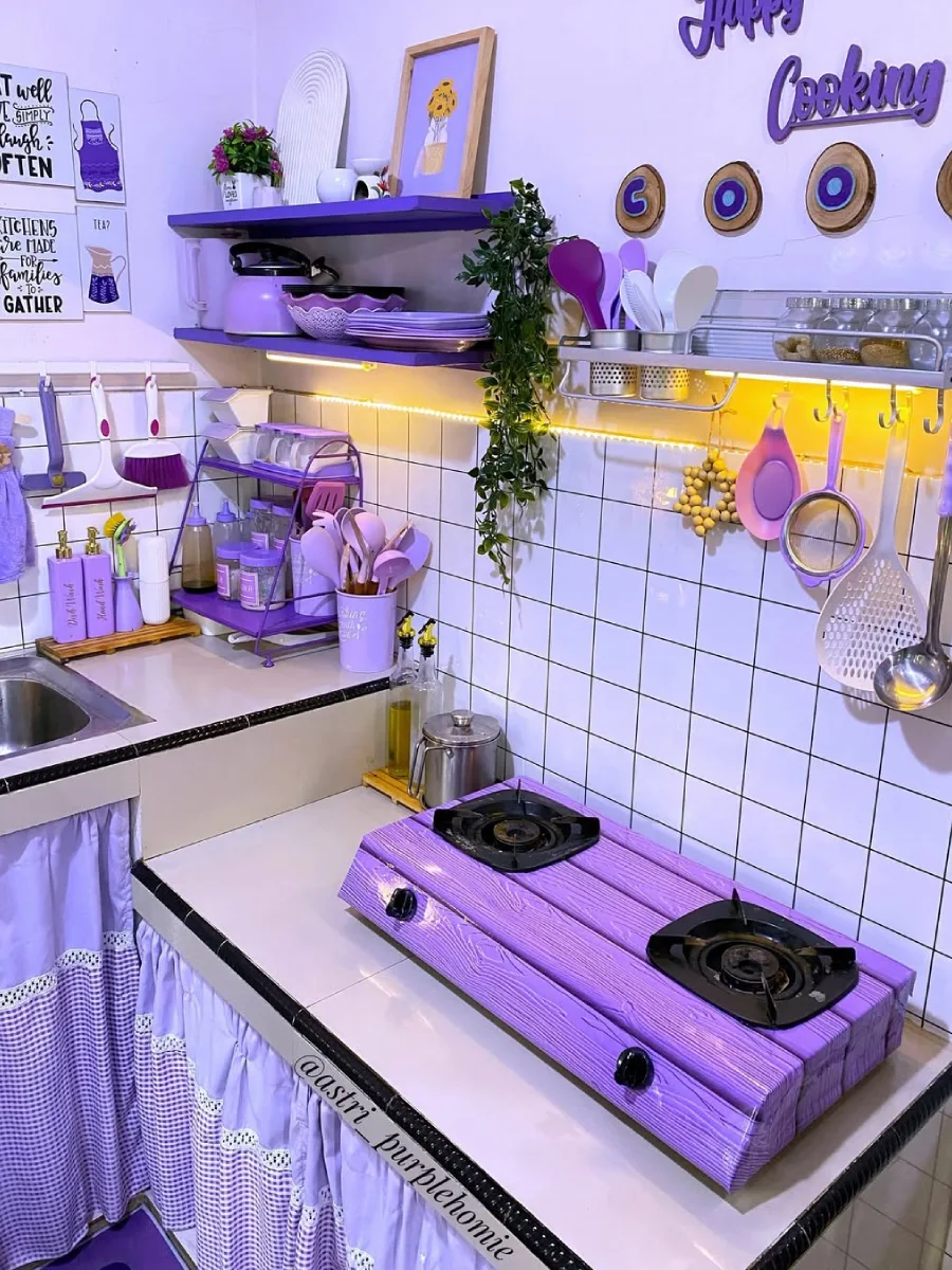 Peralatan dapur serba ungu tertata rapi di rak gantung aluminium, kompor gas ungu motif kayu, dan tanaman hias artifisial.