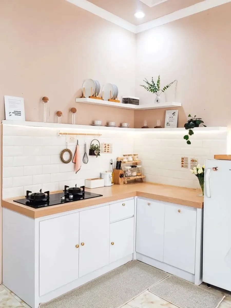 Dapur sudut (L-shape) minimalis estetik dengan cat dinding krem beige, top table motif kayu, dan rak ambalan dinding sederhana.