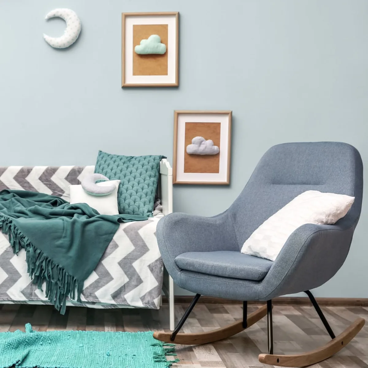 Ide warna cat kamar tidur anak atau bayi bernuansa biru langit pastel dengan kursi santai dan dekorasi dinding bentuk awan.