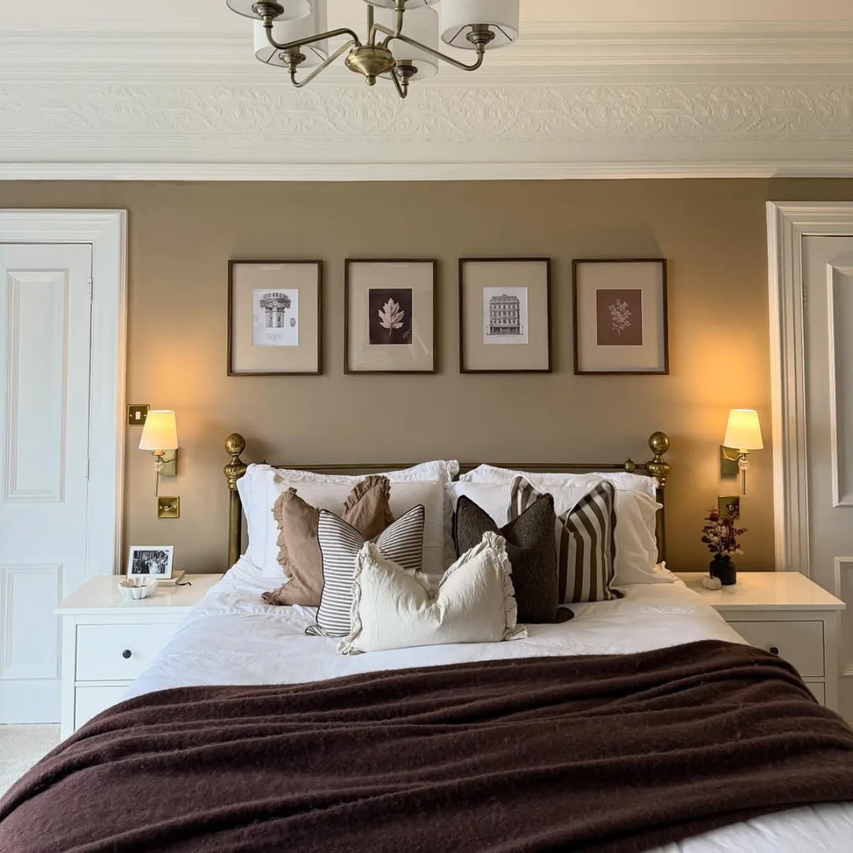 Kamar tidur bergaya klasik vintage dengan cat dinding warna cokelat taupe, detail plafon ukir, dan rangka tempat tidur kuningan.