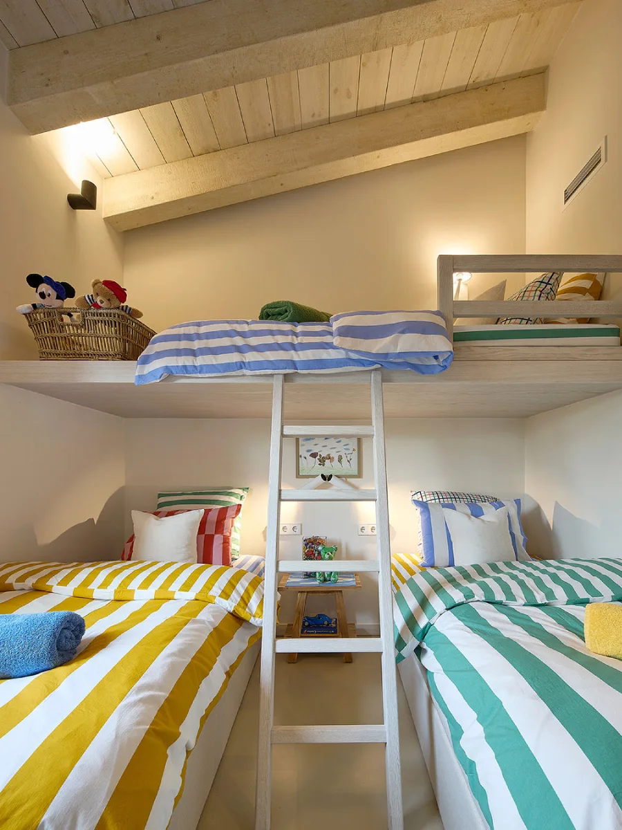 Tempat tidur anak dengan sprei bergaris dan aksesori bertema pantai.