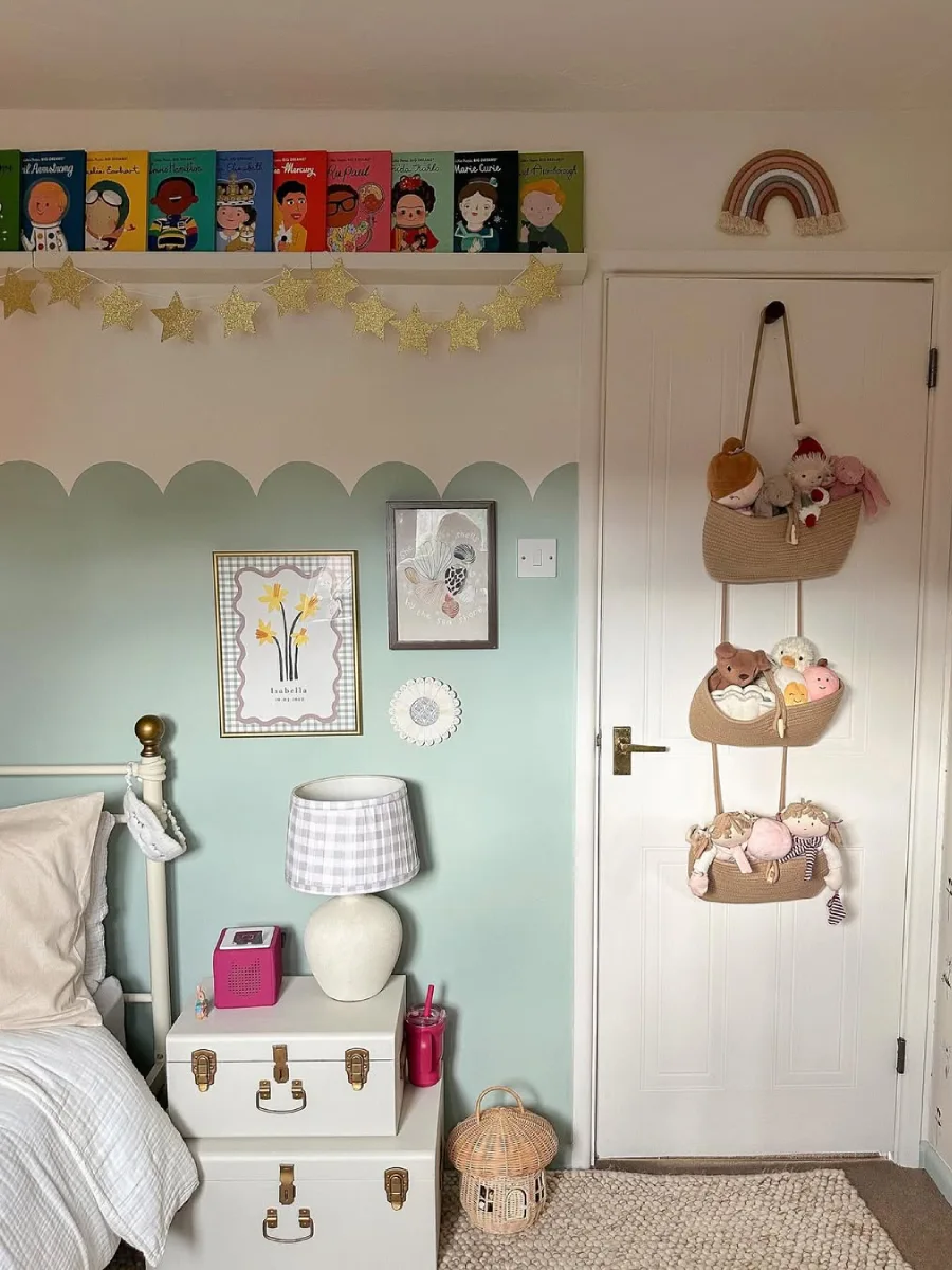 Kamar anak pastel dengan dekorasi boneka dan nuansa feminin.