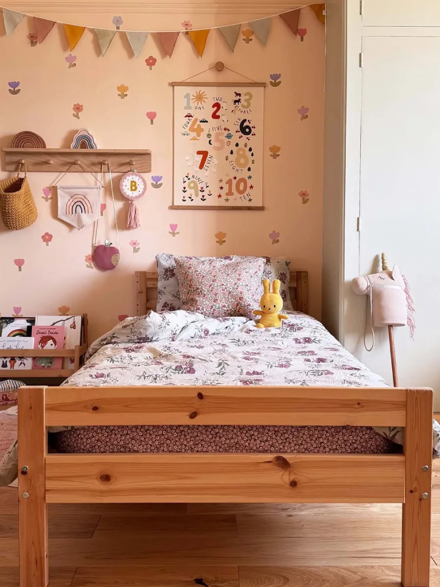 Kamar anak bernuansa hijau segar dengan rak mainan dan lemari pink mencolok.