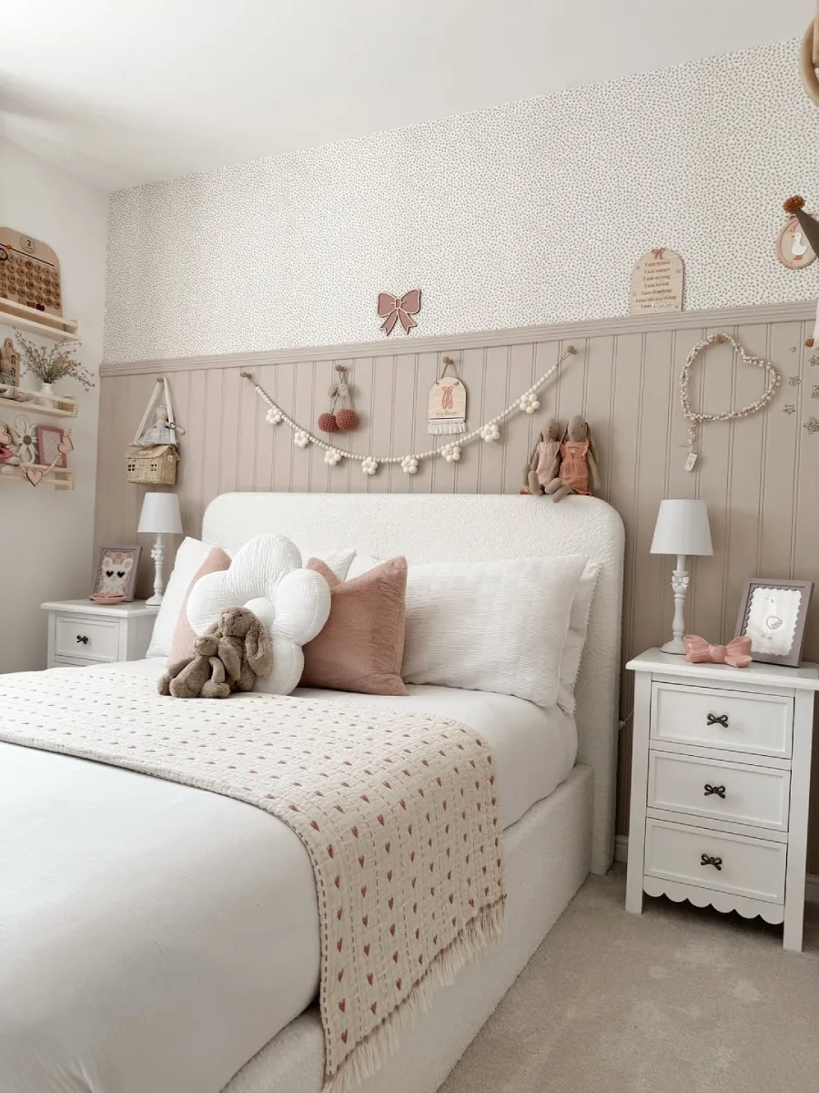 Kamar anak dengan sofa pink lembut di bawah jendela besar.