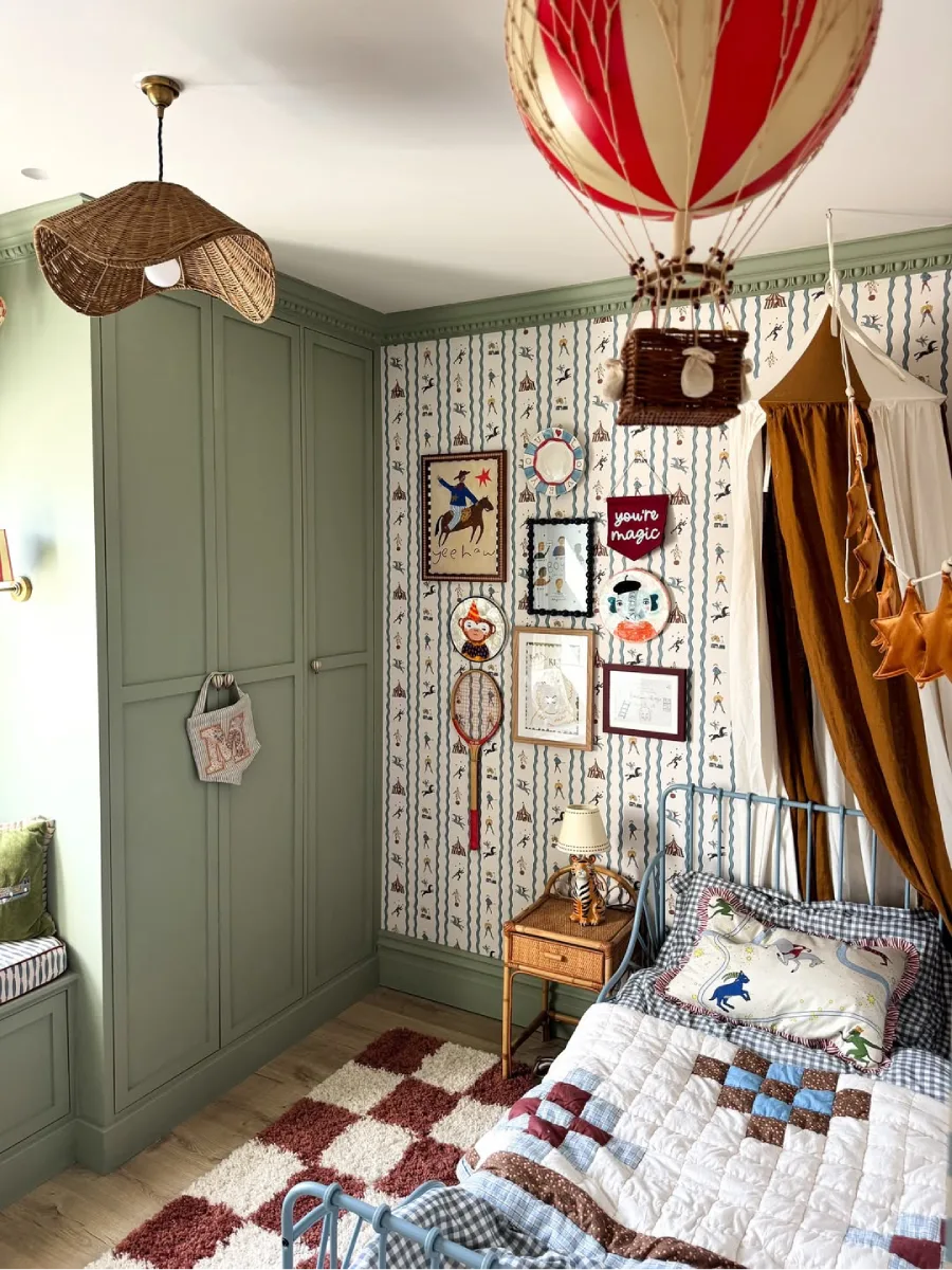 Kamar anak dengan dua balon udara gantung dan tempat tidur besi bergaya vintage.