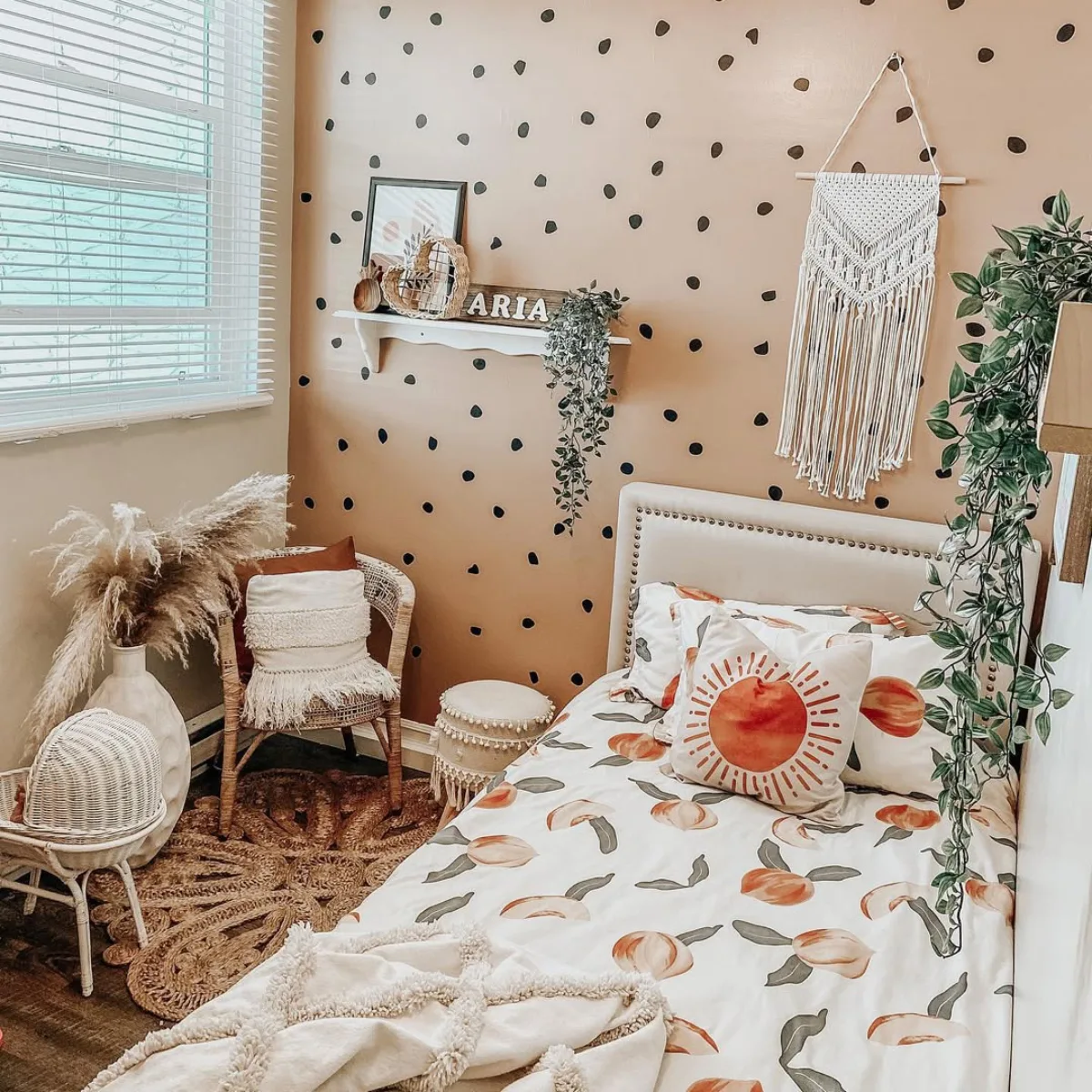 Kamar anak gaya boho dengan tanaman gantung dan hiasan dinding rotan.