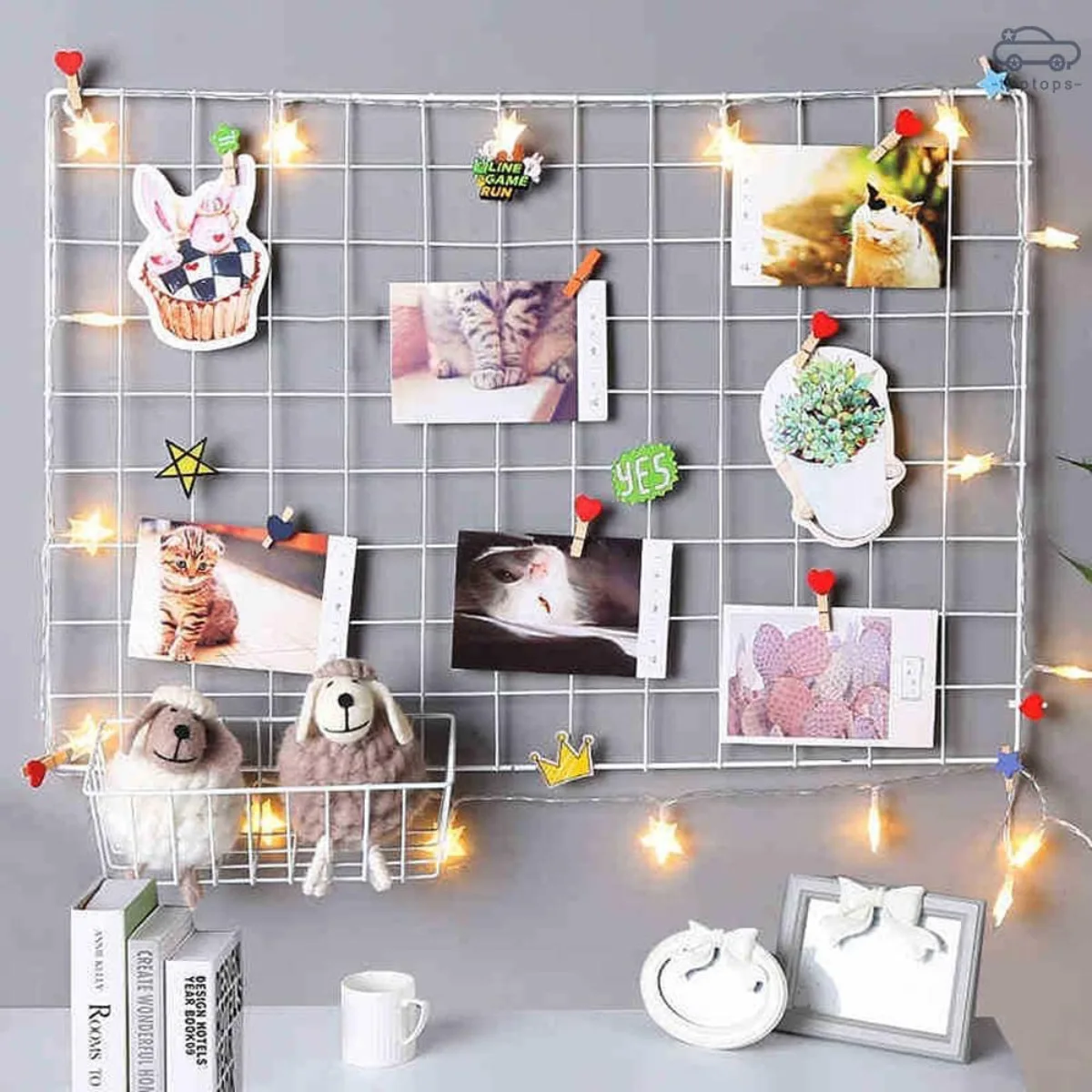 Kawat ram dinding putih yang dihiasi lampu kelap-kelip berbentuk bintang, klip kayu yang menjepit foto-foto polaroid, dan keranjang kawat yang berisi mainan.