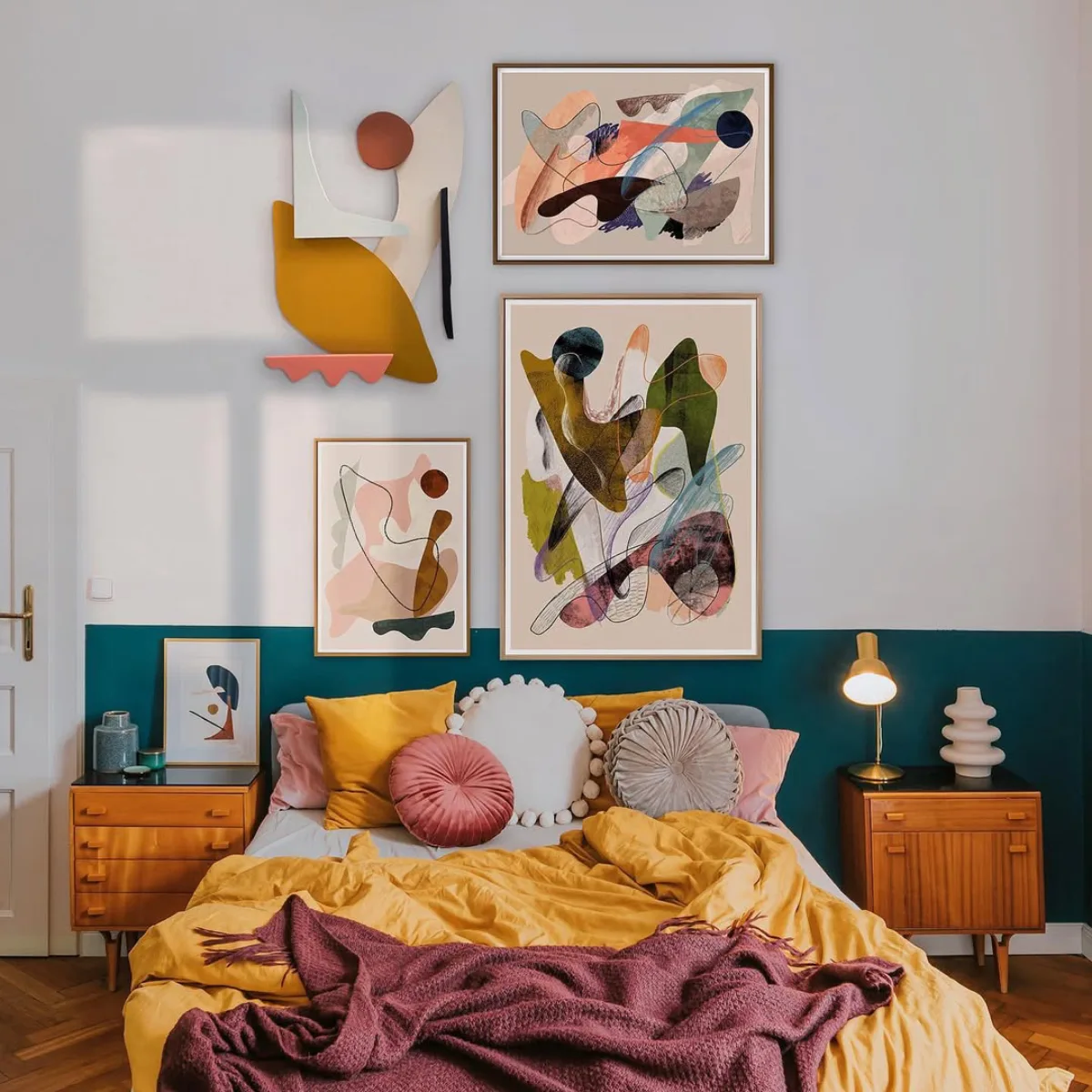 Dinding kamar tidur dua warna putih dan teal dengan dekorasi seni lukis abstrak dan elemen dinding 3D berwarna mustard merah muda dan biru dongker