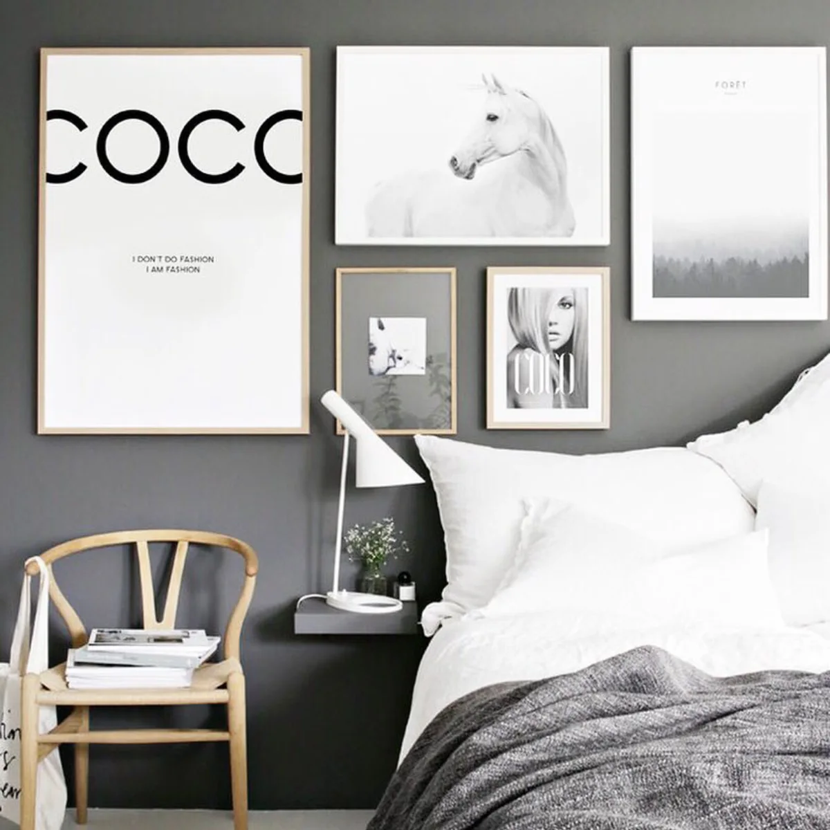 Kamar tidur dengan dinding abu-abu tua yang elegan menampilkan gallery wall hitam putih dan tipografi tebal menonjol