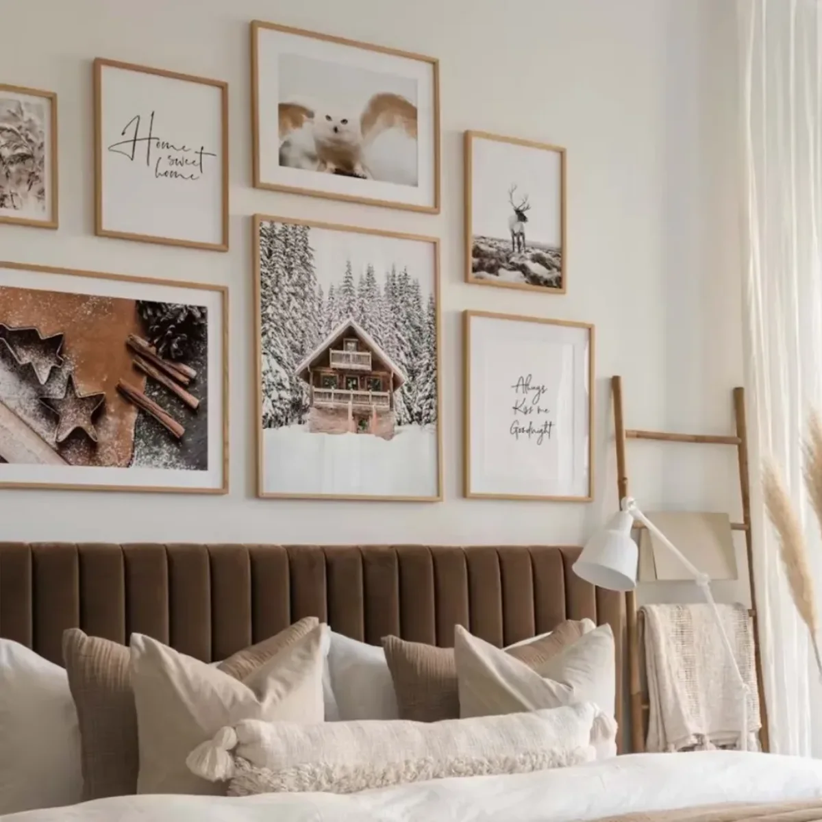 Gallery wall kamar tidur simpel bernuansa hangat dengan bingkai kayu tipis yang berisi deretan foto bertema musim dingin bersalju dan tipografi minimalis