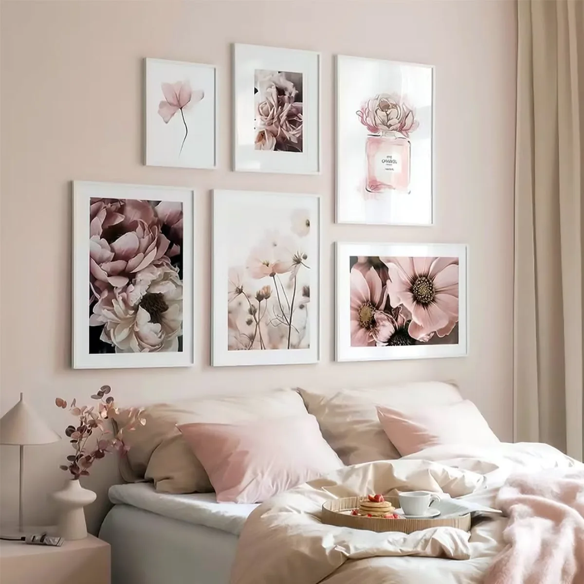 Galeri dinding kamar bernuansa merah muda lembut menampilkan susunan bingkai putih berisi foto bunga peony cosmos dan botol parfum bernuansa senada