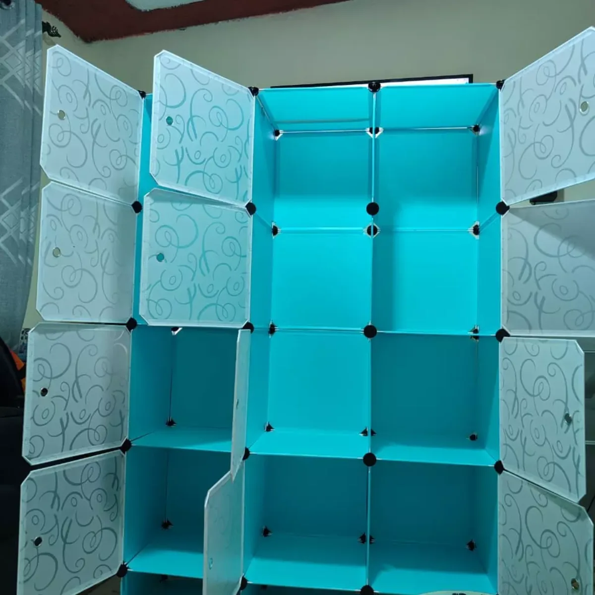 Lemari pakaian modular berbahan material plastik polimer berwarna biru dengan penutup depan bermotif