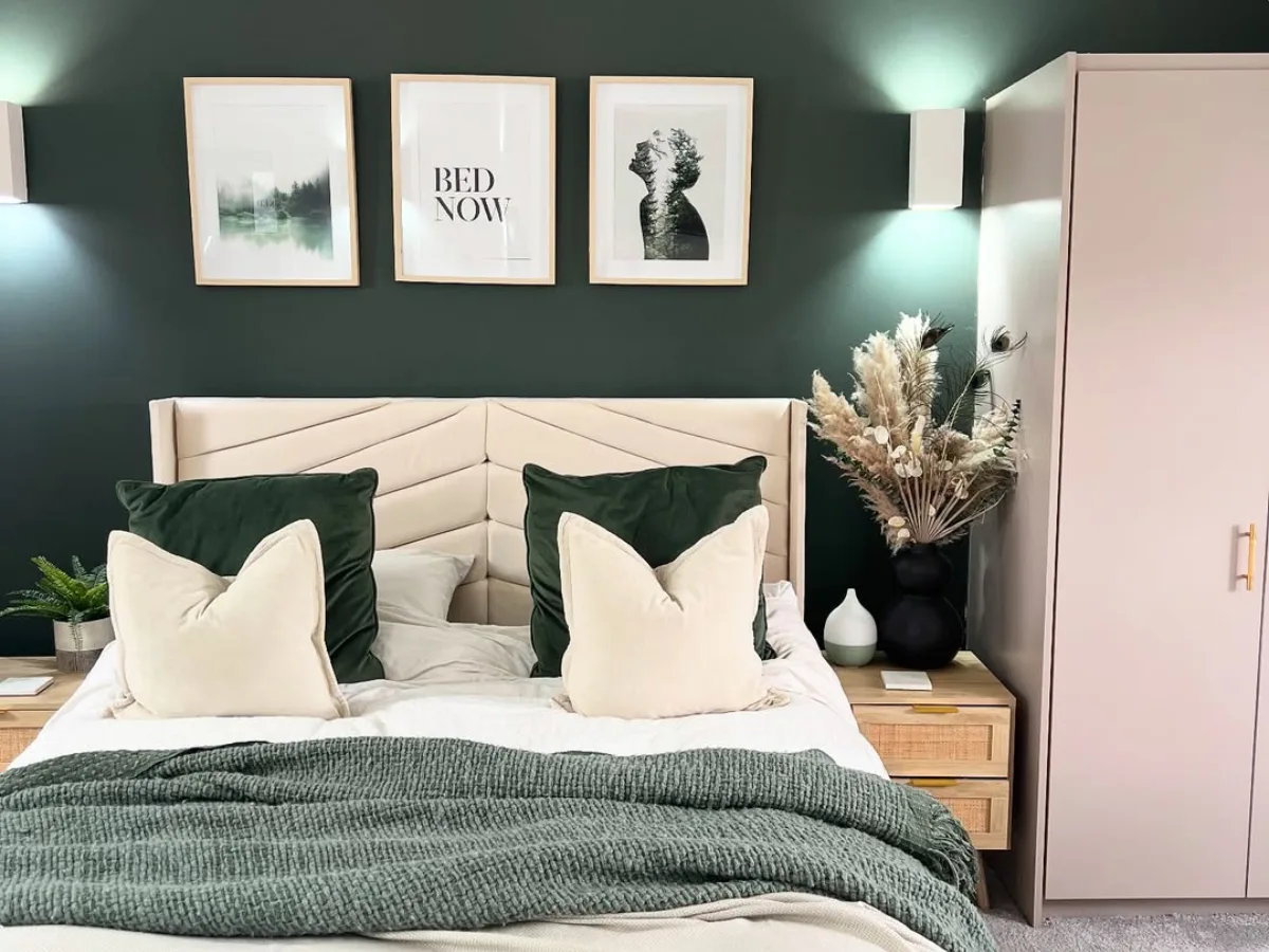 Kamar tidur dengan dinding hijau gelap bernuansa sejuk, tempat tidur putih minimalis, bantal hijau, dan pencahayaan lembut yang menenangkan