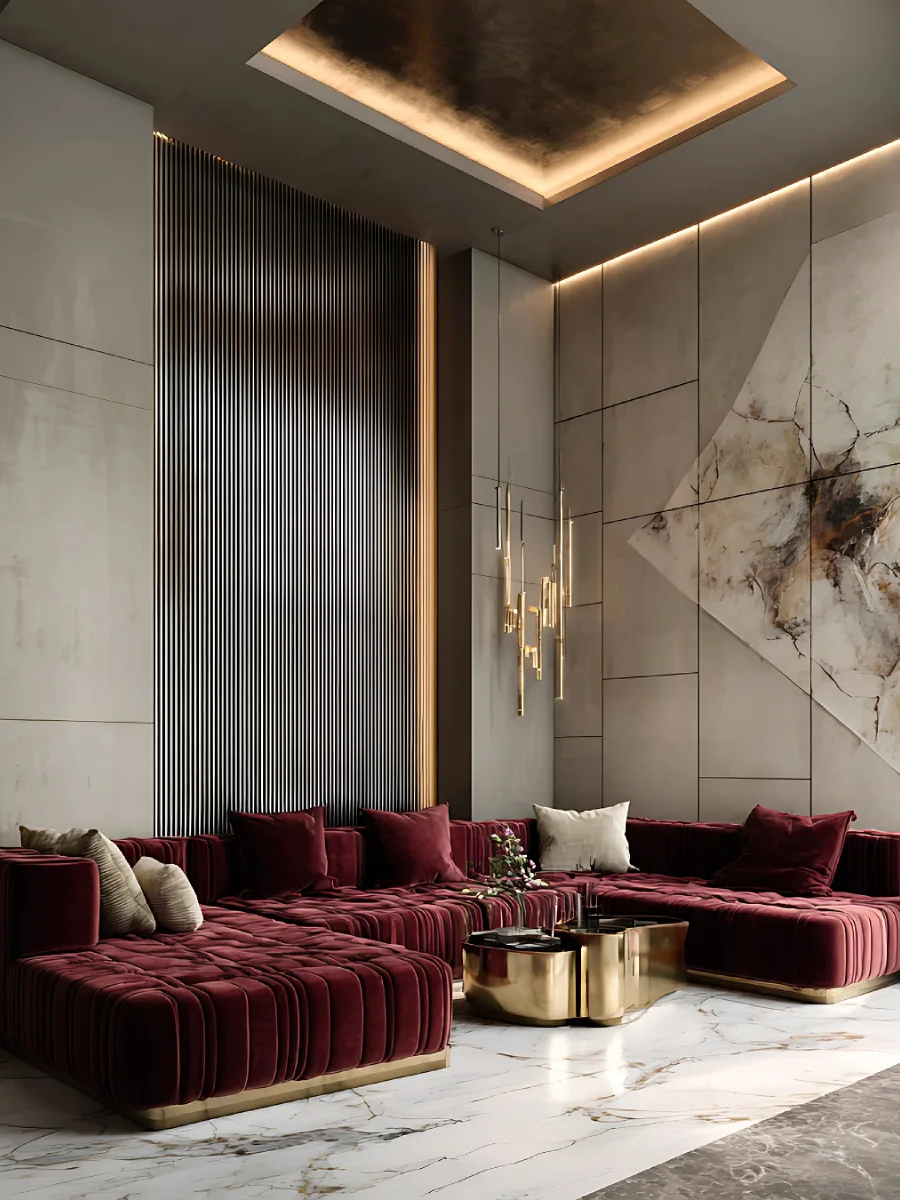 Sudut ruang keluarga modern yang menampilkan sofa merah marun rendah yang elegan. Dinding di belakangnya menggunakan panel abu-abu minimalis dengan tekstur garis-garis vertikal tipis dan lukisan abstrak besar. Pencahayaan built-in pada plafon menciptakan suasana hangat, dilengkapi meja kopi emas yang futuristik.