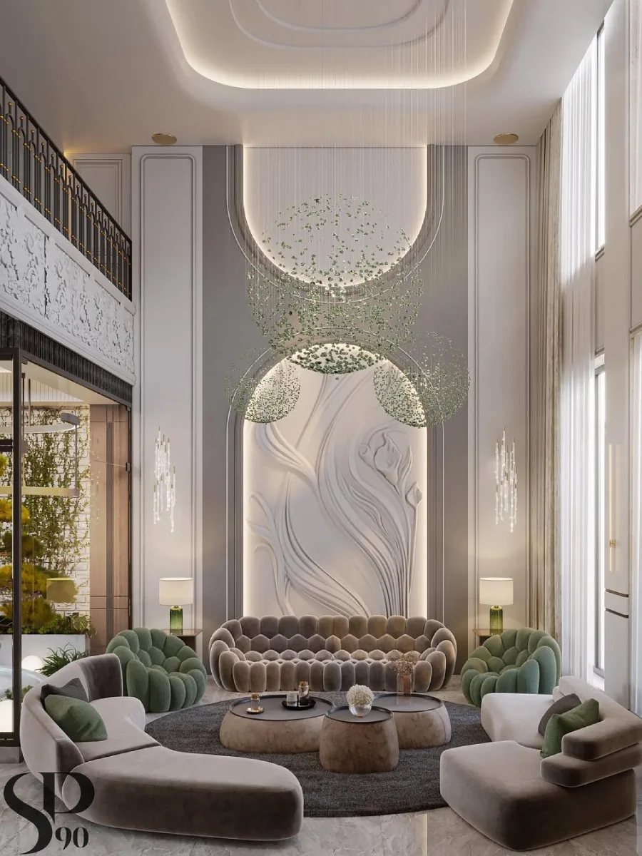 Ruang keluarga mewah dengan fokus pada dinding dekoratif panel 3D bermotif aliran organik yang lembut. Di tengah ruangan terdapat lampu kristal gantung yang membentuk pola awan melingkar, dikelilingi oleh sofa beludru bertekstur unik dan kursi armchair berwarna hijau lumut.