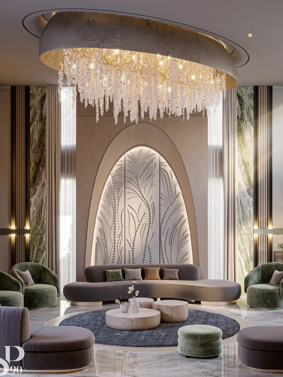 Ruang tamu mewah dengan konsep lengkungan arsitektural yang dominan pada dinding pusat bermotif ukiran daun. Lampu gantung kristal raksasa yang menjuntai memberikan kesan dramatis, dipadukan dengan sofa lengkung cokelat tua dan lantai marmer yang mengkilap.