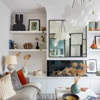 Interior rumah dengan banyak pajangan dan rak terbuka yang terlihat rapi tapi terasa padat dan ramai