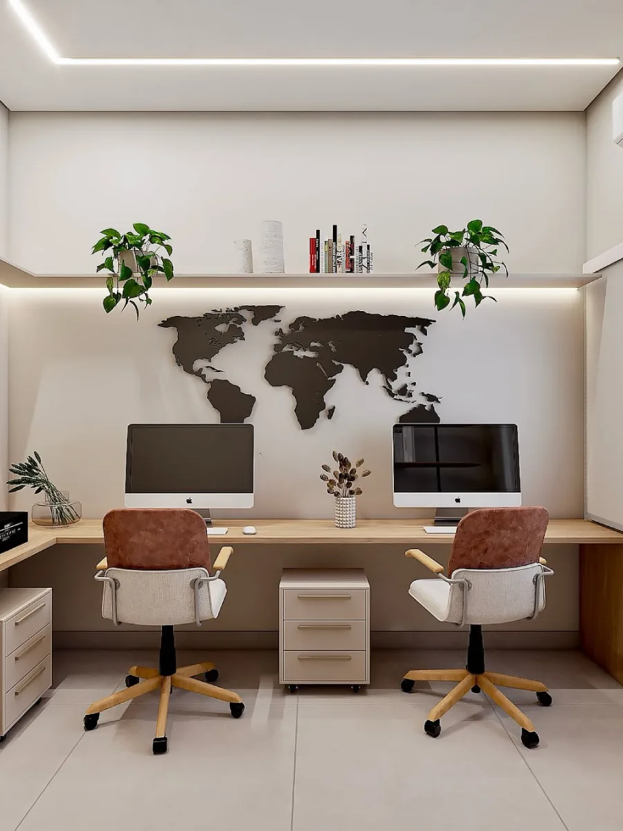 Ruang kerja moden dan terang dengan meja kayu memanjang untuk dua orang, dua kerusi beraksen kulit coklat, rak ambalan dengan tanaman hiasan, dan hiasan dinding berbentuk peta dunia 3D berwarna hitam.