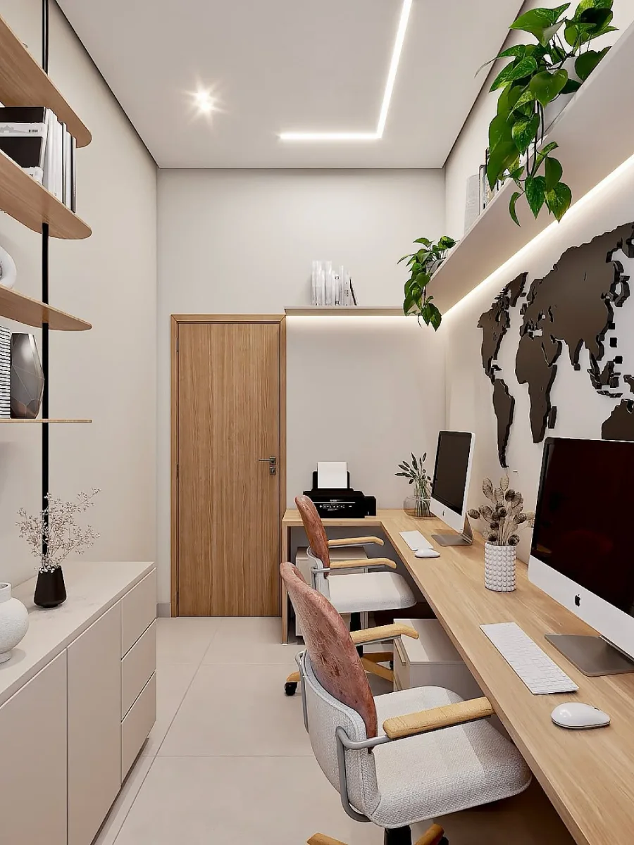 Pandangan ruang kerja dua orang bernuansa cerah menghadap pintu kayu, menampilkan meja panjang, peta dunia hitam di dinding, kabinet simpanan krem, dan lantai berwarna cerah yang bersih.