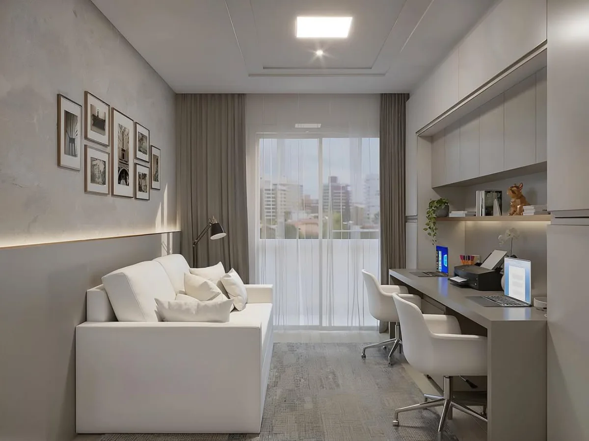 Keseluruhan tata letak home office memanjang yang menampilkan area meja kerja untuk dua orang di satu sisi dan sofa putih untuk bersantai di sisi lainnya.