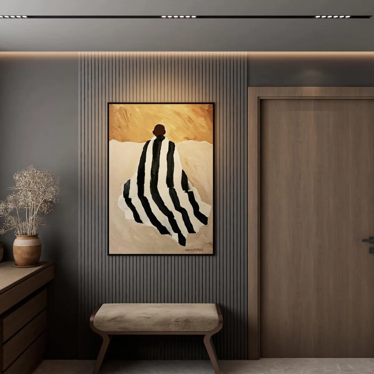 Area sudut dekat pintu ruang kerja menampilkan dinding berpanel garis abu-abu, lukisan abstrak besar, dan bangku (bench) dengan bantalan empuk.