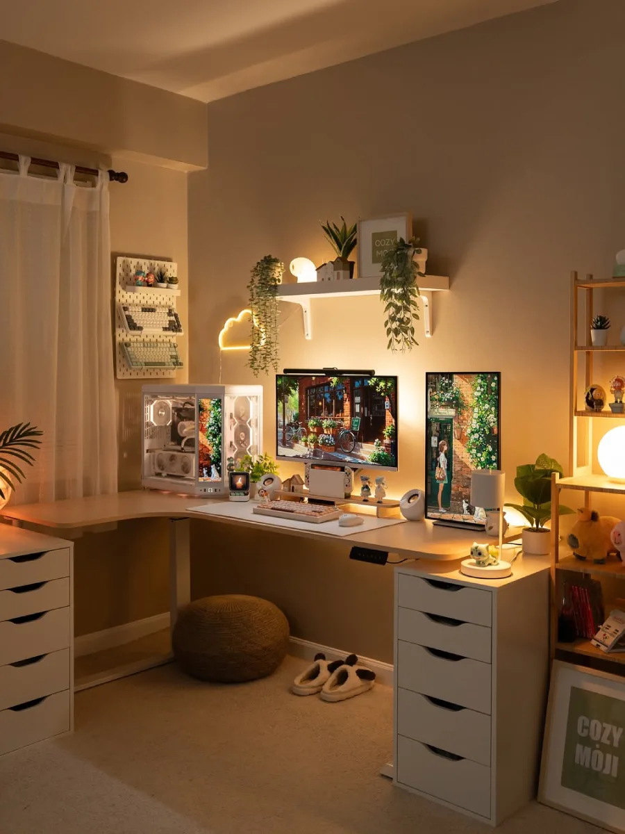 Setup meja kerja estetik L-shape dengan wallpaper pemandangan jalanan estetik di layar monitor ganda, diapit oleh dua kabinet laci penyimpanan berwarna putih di bawah meja.