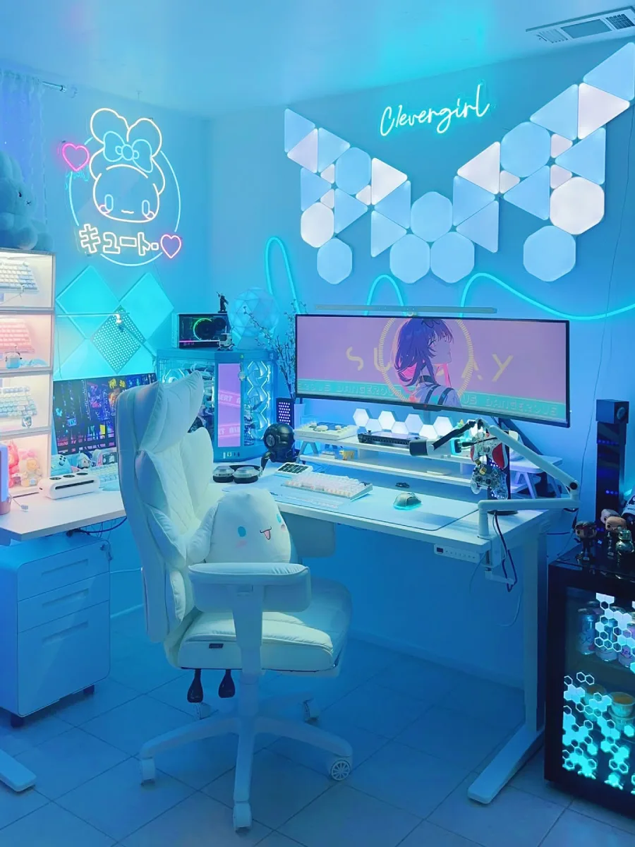 Meja kerja gaming wanita dengan tema neon biru yang estetik. Terdapat kursi putih berbulu yang dilengkapi boneka Cinnamoroll, monitor lebar dengan wallpaper anime, serta hiasan lampu dinding geometris dan tulisan neon 