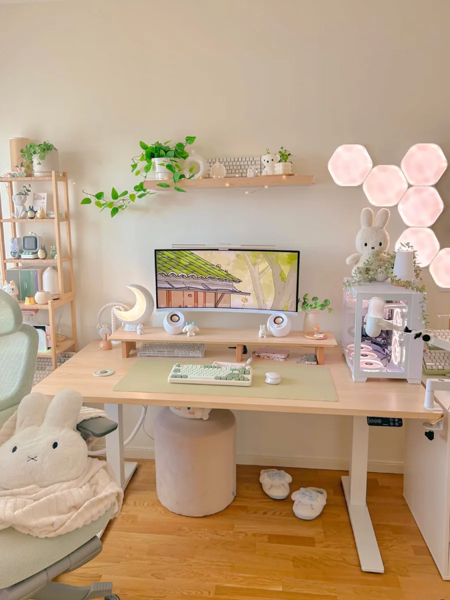 Tampak depan setup meja kerja berelemen kayu yang bersih dan rapi. Menampilkan layar monitor lengkung di atas stand kayu, rak gantung dengan tanaman hias rambat, keyboard nuansa hijau-putih, lampu heksagonal berpendar lembut, dan boneka kelinci Miffy di atas PC case.