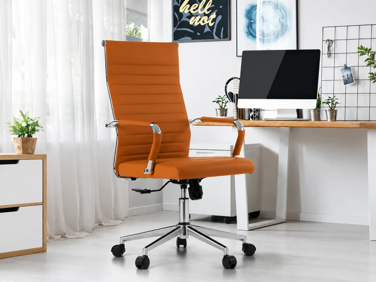 Kursi kerja cokelat modern dengan roda dan sandaran tinggi di ruang home office minimalis berwarna putih, lengkap dengan meja kayu dan komputer desktop.