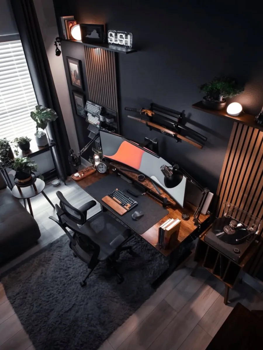 Sudut pandang dari atas (top-down) untuk tata letak home office modern, memperlihatkan meja kayu di atas karpet berbulu abu-abu, sofa santai, dan kabinet pemutar piringan hitam.