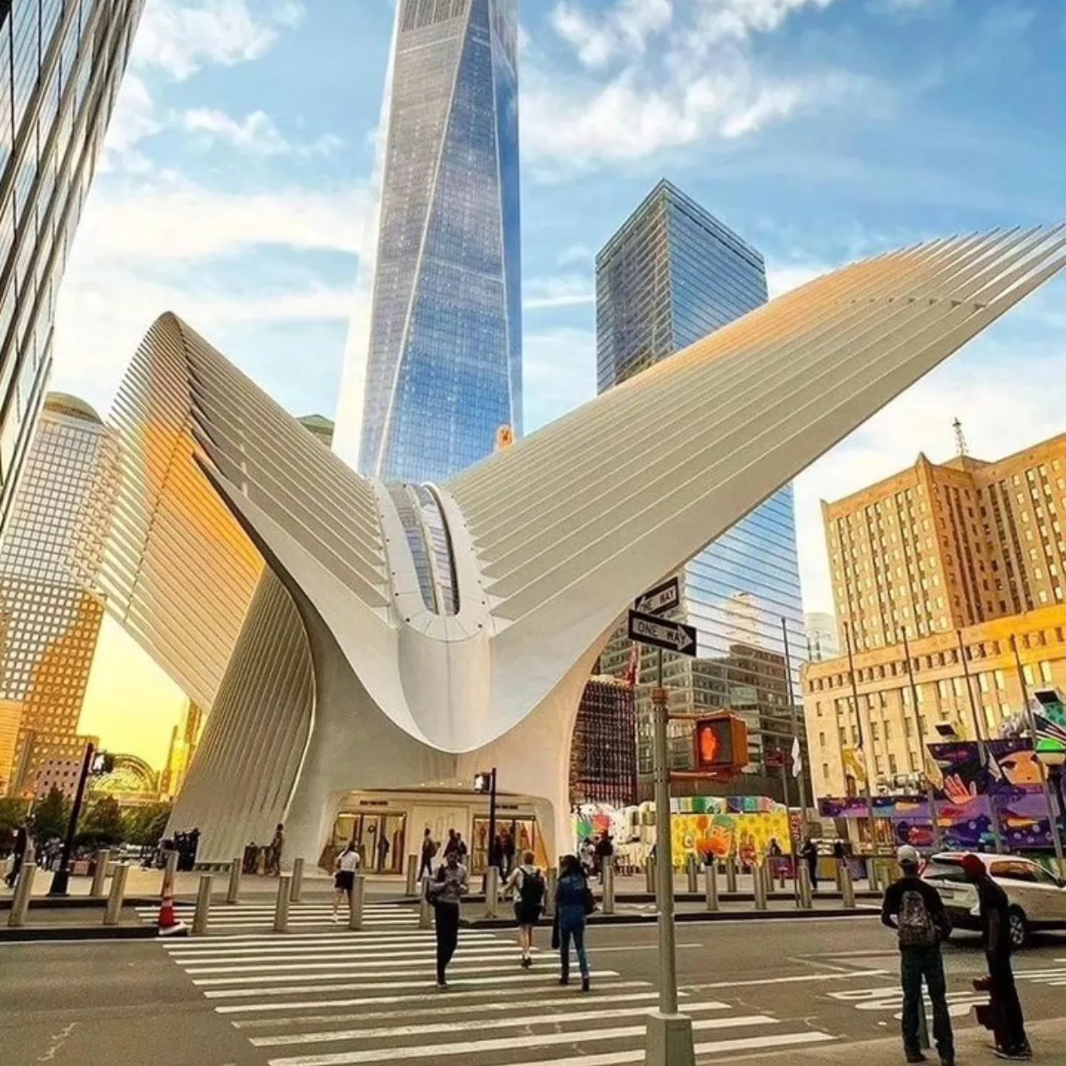 Pemandangan dari jalanan menunjukkan struktur putih Oculus yang unik dan menara One World Trade Center yang tinggi di New York City