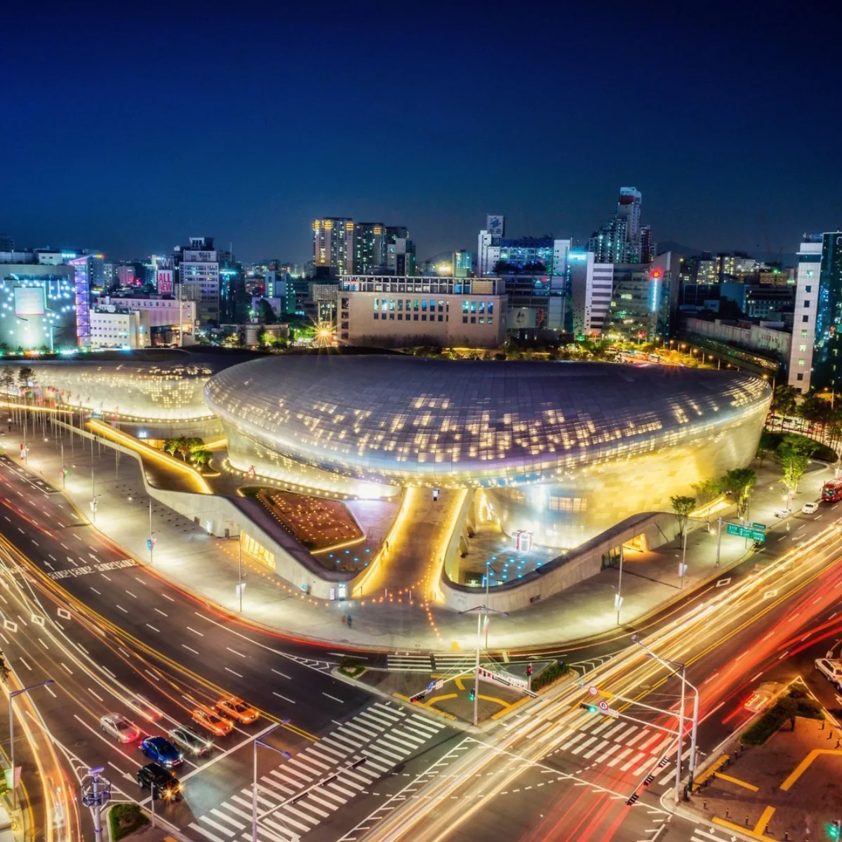 Foto eksterior Dongdaemun Design Plaza di Seoul, Korea Selatan, menonjolkan desain arsitektur melengkung yang mulus dan fasad aluminium