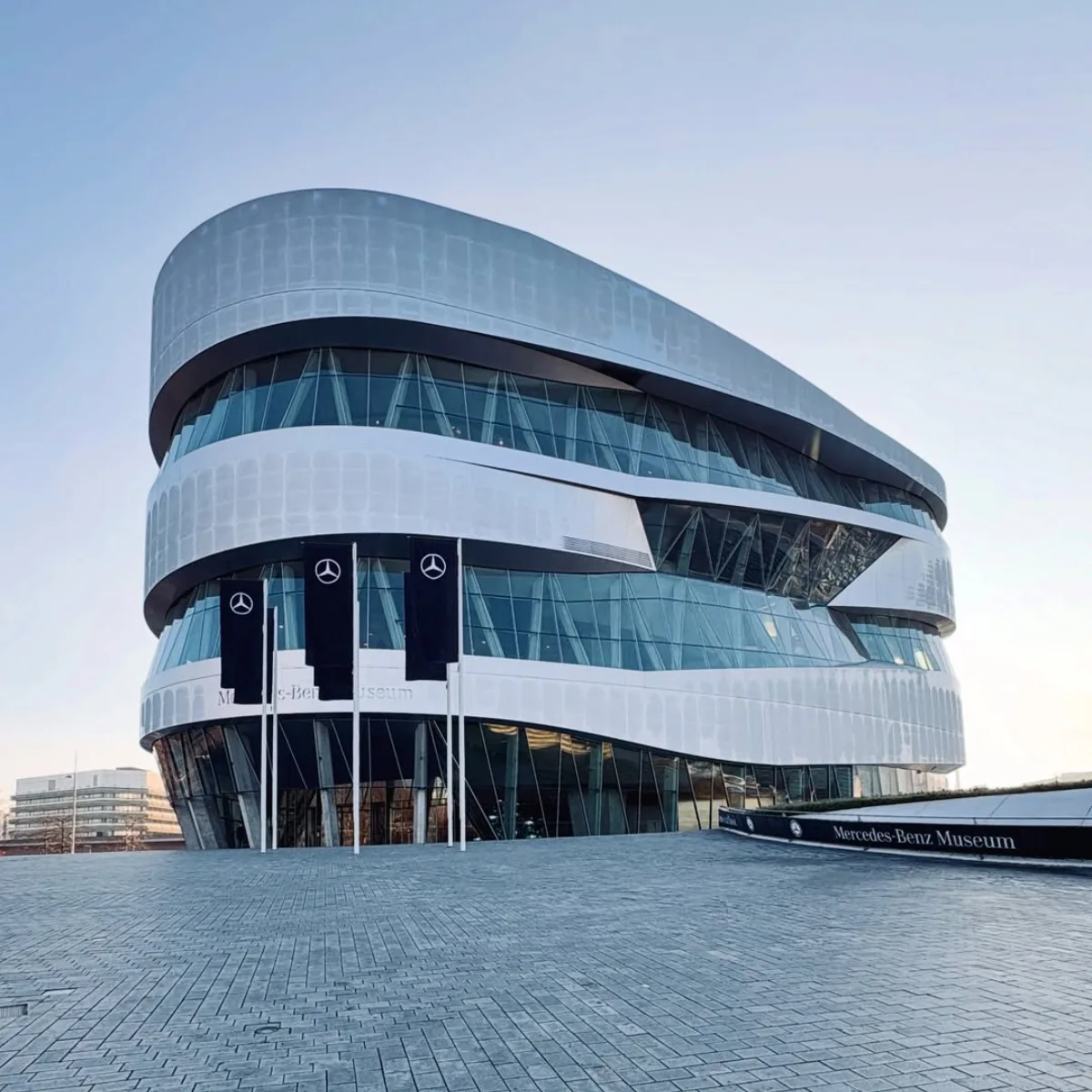 Foto eksterior Museum Mercedes-Benz yang futuristik di Stuttgart, Jerman, dengan desain arsitektur melengkung dan kaca