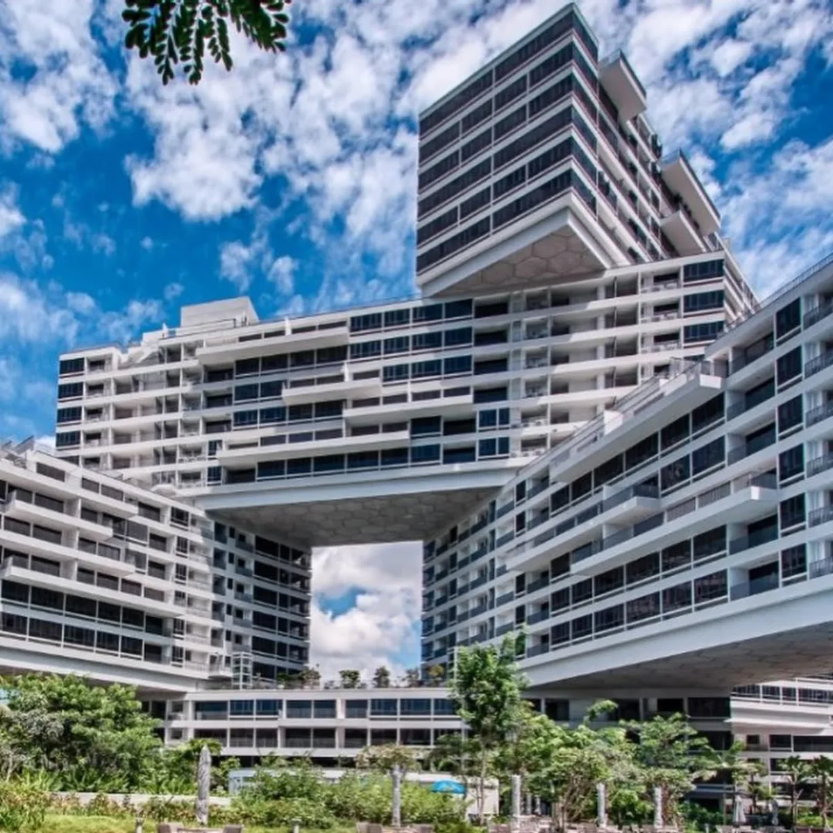 Kompleks apartemen The Interlace yang memiliki arsitektur unik berupa blok-blok bangunan putih yang disusun bertumpuk dan menyilang dengan fasilitas kolam renang biru di area bawahnya