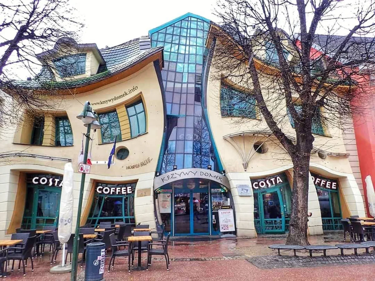 Crooked House fasad bangunan komersial bertingkat yang desainnya tampak melengkung dan meleleh seperti distorsi optik dengan jendela dan pintu yang tidak simetris