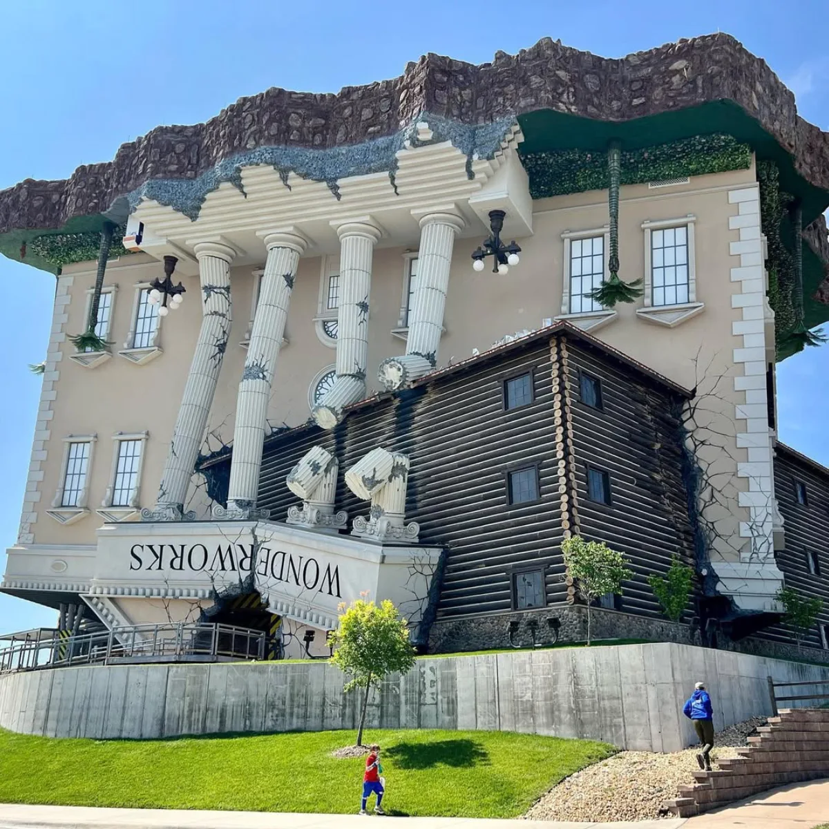 WonderWorks bangunan besar bergaya klasik yang didesain terbalik seolah olah jatuh dari langit dengan pilar dan atap retak yang menempel pada tanah