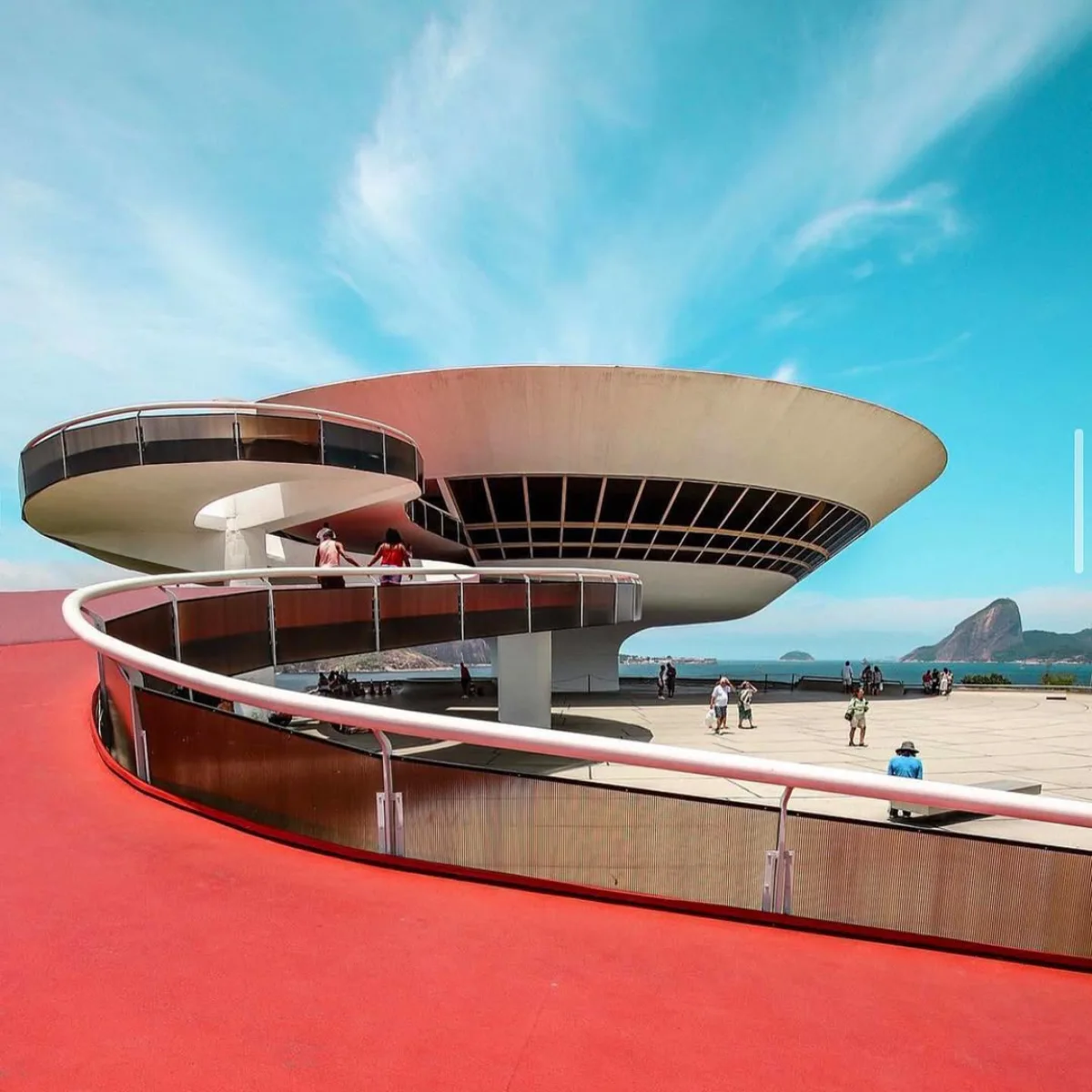 Niteroi Contemporary Art Museum museum berwarna putih dengan bentuk melingkar menyerupai piring terbang atau UFO yang memiliki jalan setapak melengkung berwarna merah cerah