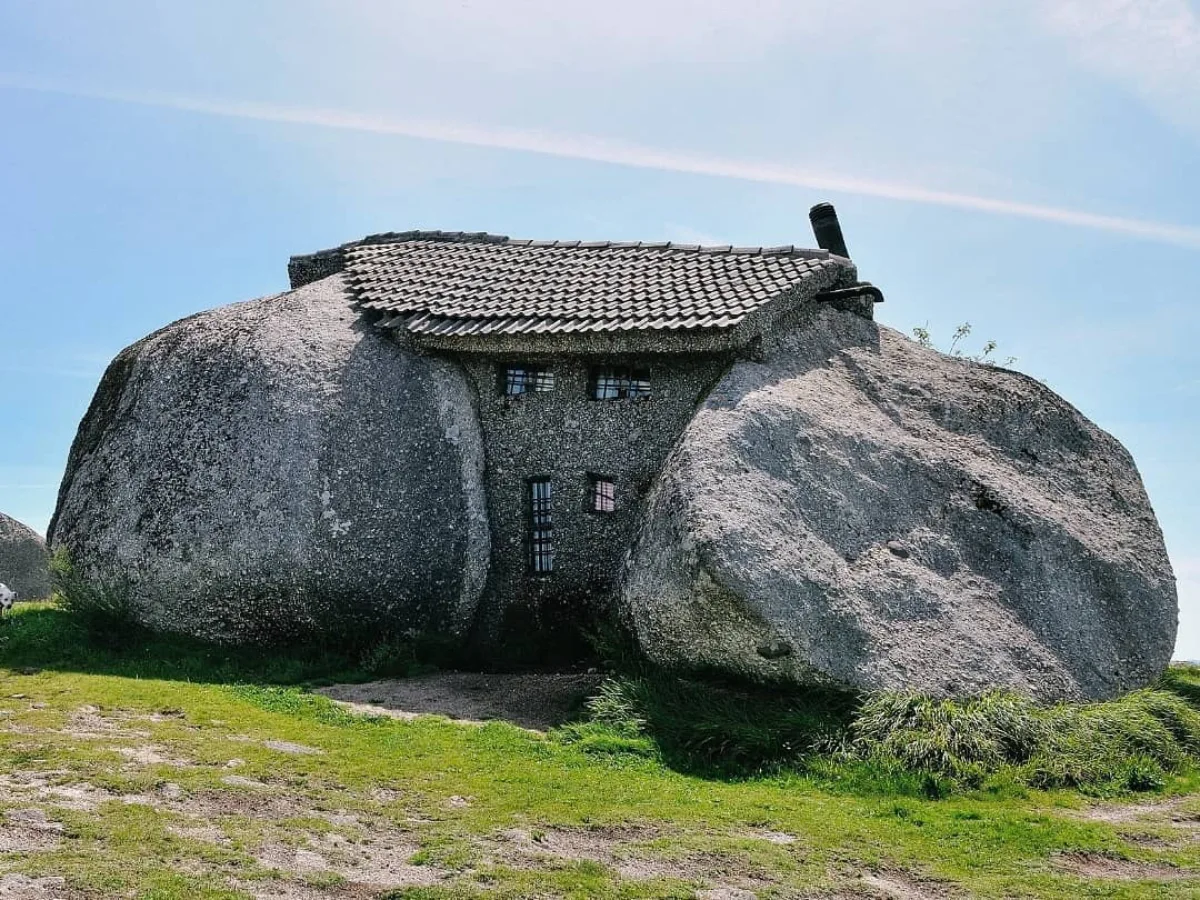 Stone House rumah kecil beratap genteng yang dibangun menyatu di antara bongkahan batu granit raksasa alami di area padang rumput hijau