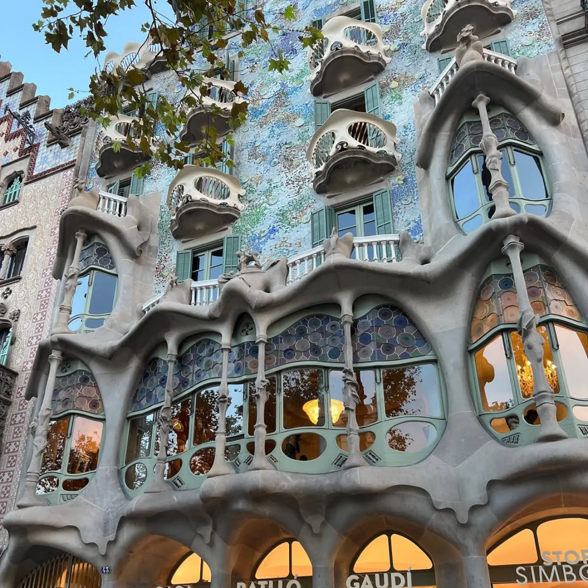 Casa Batllo fasad gedung berdesain organik dengan pilar pilar batu mirip tulang belulang dan jendela melengkung asimetris karya Antoni Gaudi