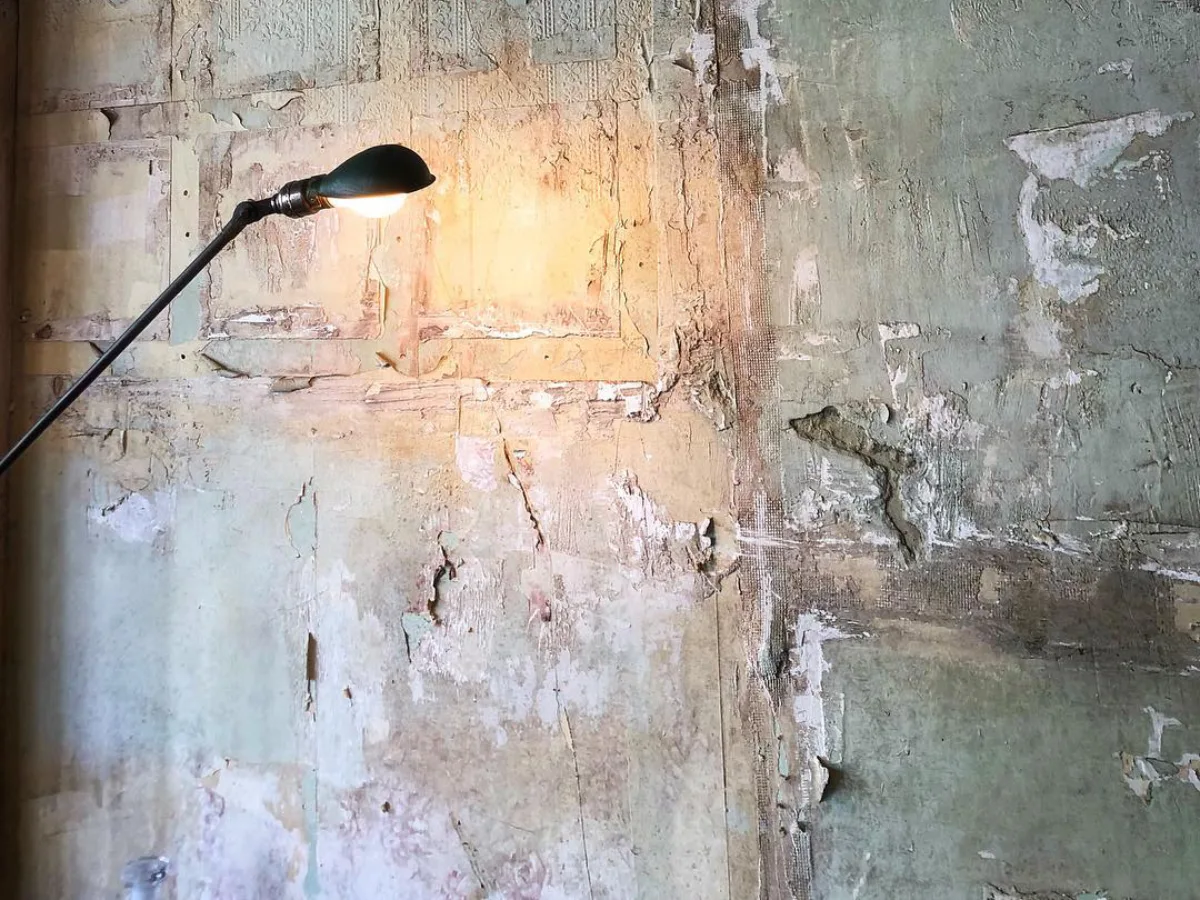 Dinding dalam rumah dengan kerak putih dan lapisan cat rusak akibat kelembapan