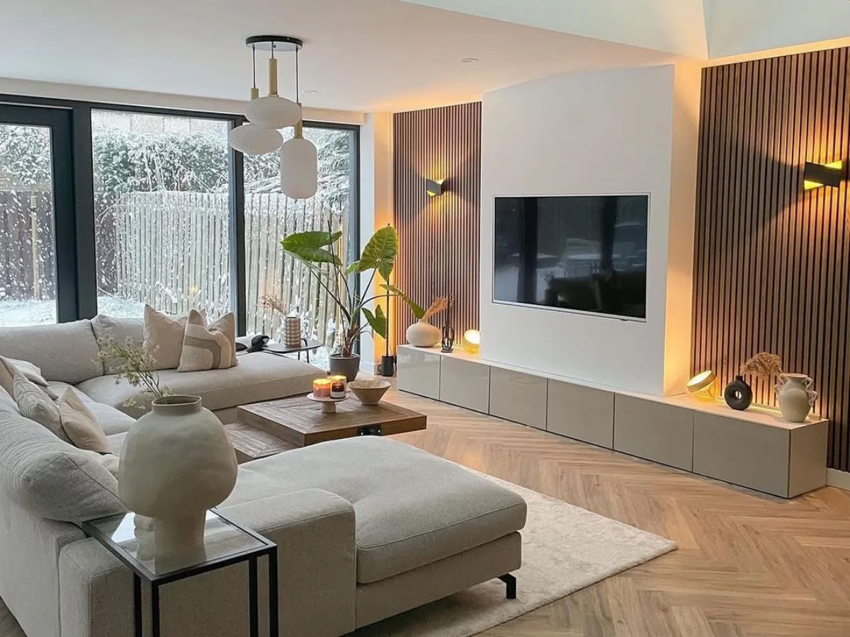 Contoh desain interior rumah modern minimalis dengan ruang tamu terbuka, sofa netral, lantai parket, dan aksen kayu.