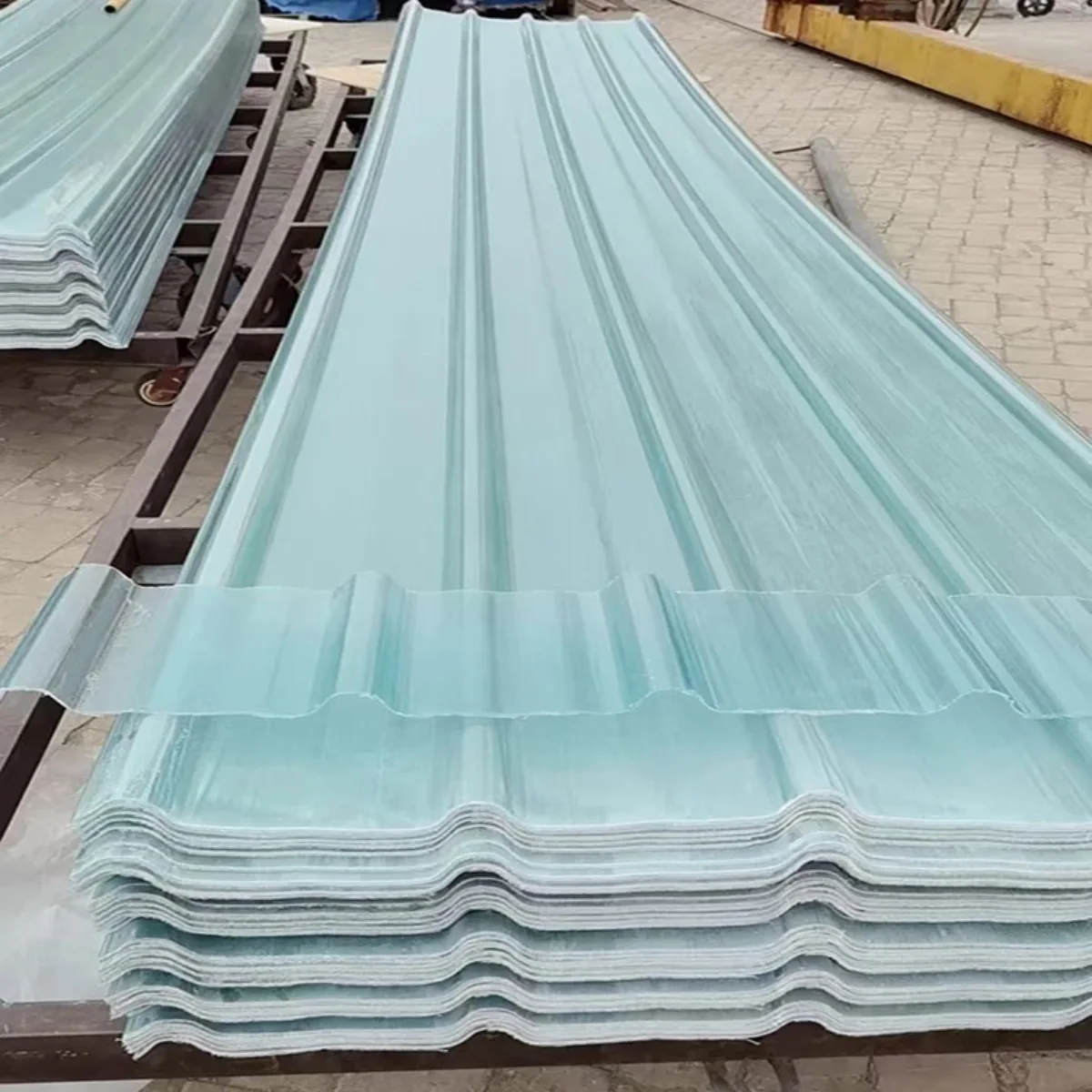 Tumpukan lembaran material atap fiberglass bergelombang dengan warna biru muda yang semi transparan