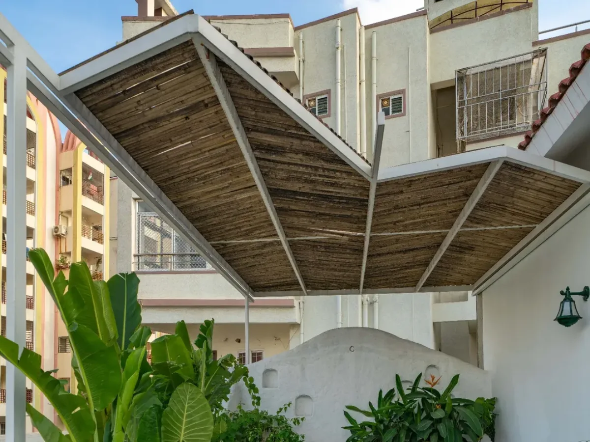 Kanopi peneduh area teras yang terbuat dari susunan bilah bambu alami dengan topangan rangka besi berwarna putih